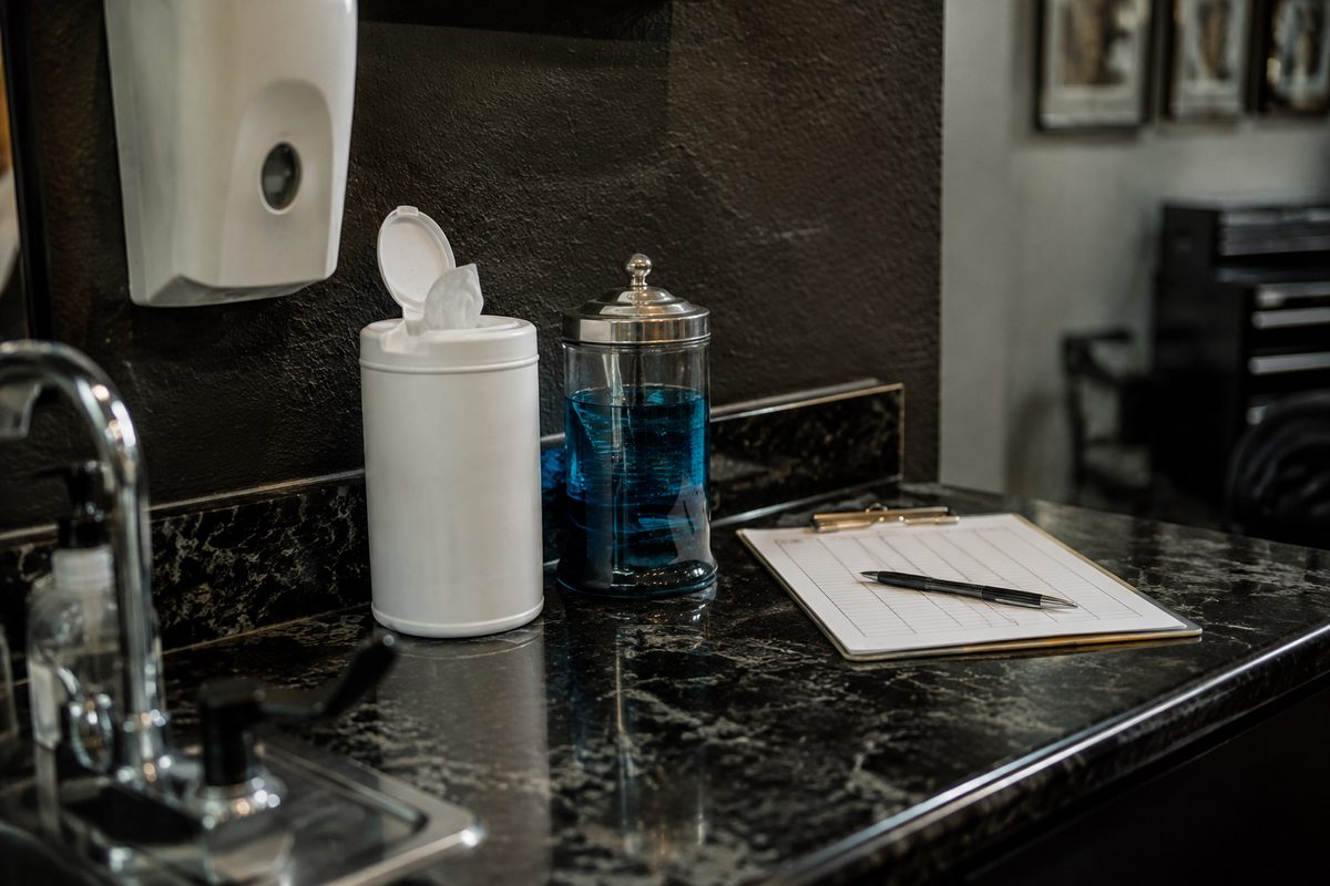 Studio sanitation counter with hospital-grade disinfectants and sterilization logbook